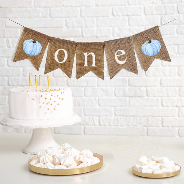 Celebrate one with this blue watercolor pumpkin burlap banner. With unique watercolor blue pumpkins on each end and the letters o n e spelled out in between in white lowercase letters, this banner is perfect for a fall first birthday celebration.