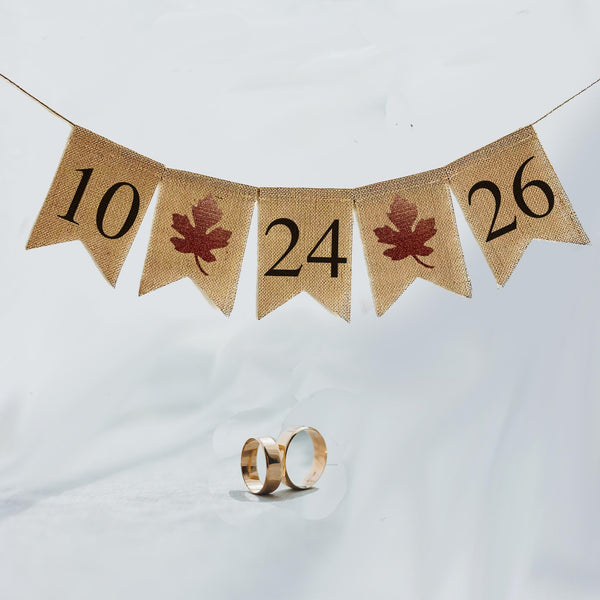 This customizable date banner allows you to add your custom date in black numbers over fishtail burlap flags. Between each number in the date there is an orange  glitter maple leaf.