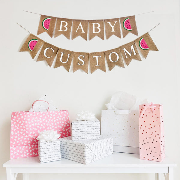 This customizable watermelon themed burlap banner has two rows. The first row says Baby with a pink, white and green hand stenciled watermelon on either side of the word. On the second line, you have two watermelon on either end surrounding your choice of custom wording. Add a date, name or phrase to customize your celebration and creating long lasting memories.
