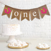 First Birthday Burlap Banner. With pink and yellow hibiscus flowers on either end of the banner, the letters spell out o n e in white on burlap flags.