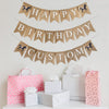 A burlap banner made from 4.5 by 6.5 inch fishtail shaped flags. Each flag has a pocket across the top for stringing. The top line says HAPPY in white capital letters with a hand stenciled image of a brown horse with a pink saddle on each end. The middle line says BIRTHDAY in white capital letters. The bottom line can be customized with a name or word of your choosing in white capital letters and also has a horse image on each end. It is strung on three 110 inch jute strings.