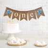 one first birthday banner with grey elephants with white ears on each end. the banner spells out o n e in lowercase white letters on burlap flags.