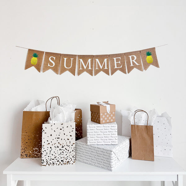 Summer Burlap Banner. Summer is written in white lettering on burlap flags with a hand stenciled yellow and green pineapple image flag on each end of the word.